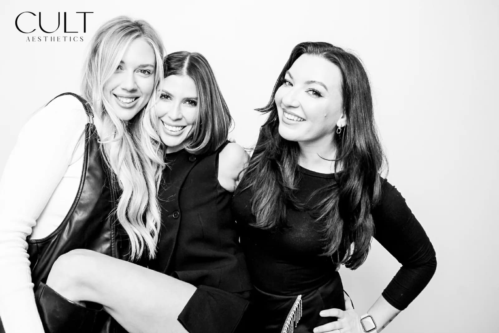 Three friends mid-laugh, glam photo booth