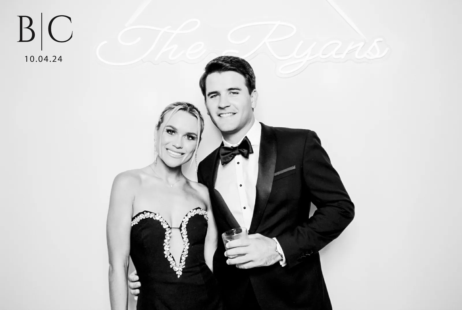Couple with custom neon sign, black and white glam booth